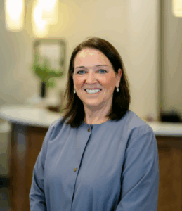 Dental assistant smiling warmly in a professional setting at Progressive Dental Care, emphasizing patient comfort and care.