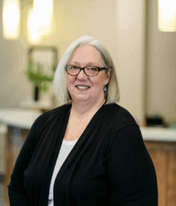 Admin team member at Progressive Dental Care smiling in a professional setting, showcasing a welcoming atmosphere for patients.