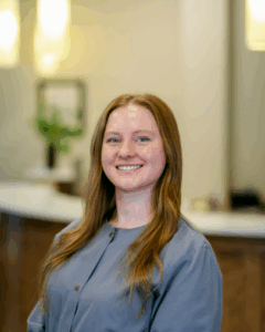Hygienist smiling in a dental office, showcasing a welcoming atmosphere at Progressive Dental Care.
