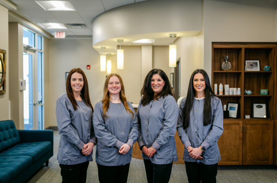 Hygienist team at Progressive Dental Care in professional attire, smiling, standing in a bright dental office setting with modern decor and a welcoming atmosphere.