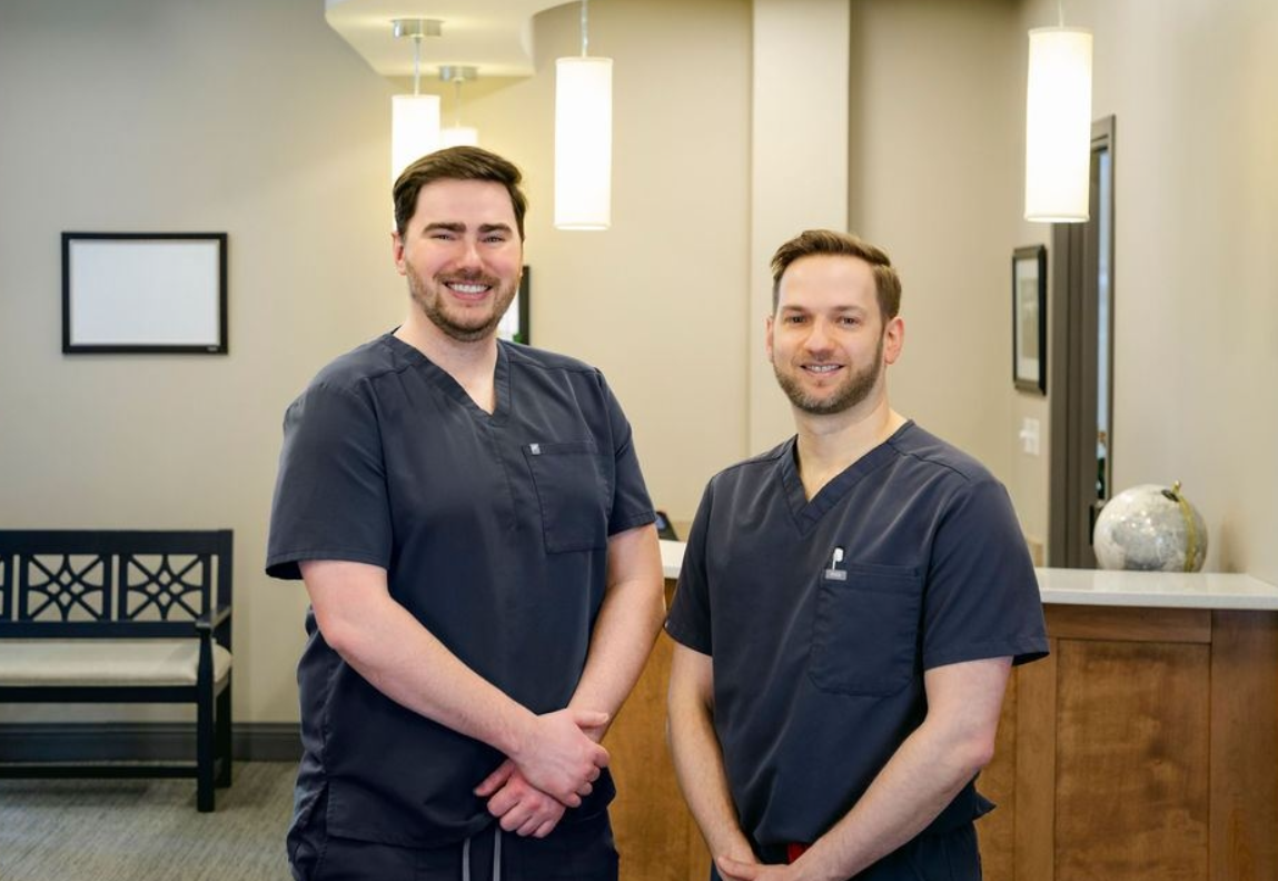 Two male dentists in scrubs smiling in a modern dental office, showcasing a welcoming environment for Progressive Dental Care in South Portland, ME.