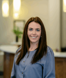 Hygienist at Progressive Dental Care smiling in a professional setting, highlighting the team's commitment to patient comfort and care.